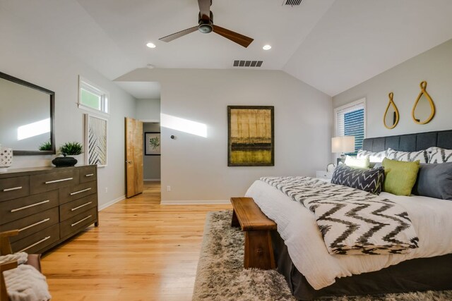 bedroom featuring light wood-style floors, baseboards, vaulted ceiling, and visible vents