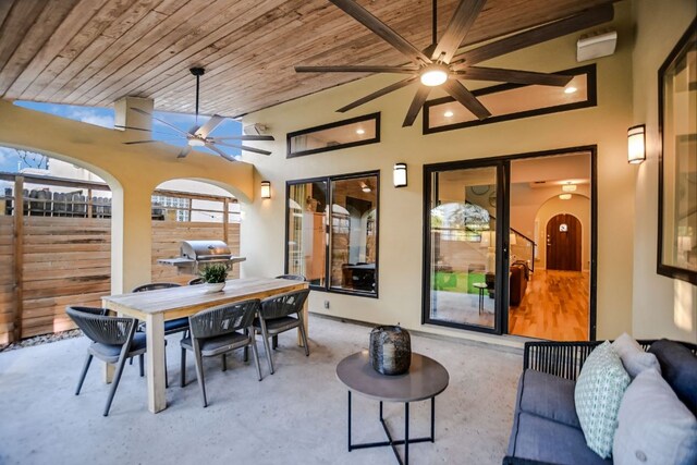 view of patio featuring area for grilling, ceiling fan, fence, and outdoor dining area