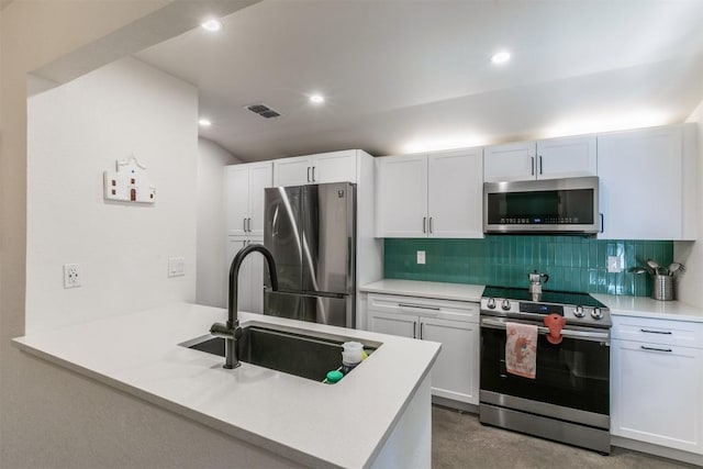 kitchen with a peninsula, decorative backsplash, a sink, and stainless steel appliances