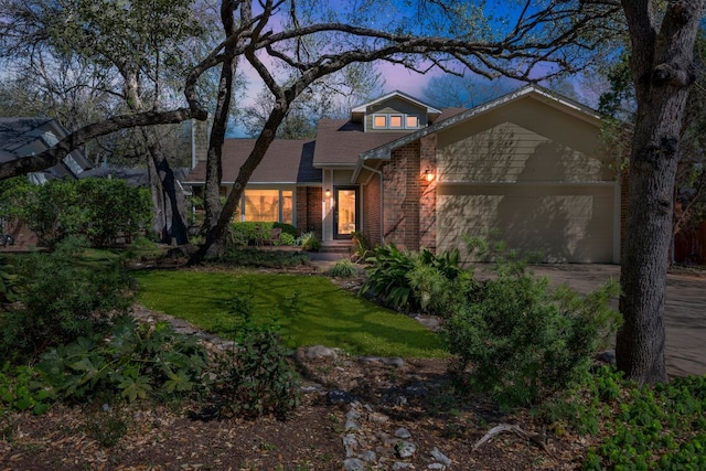 view of front of property featuring brick siding, a garage, driveway, a front yard, and a shingled roof