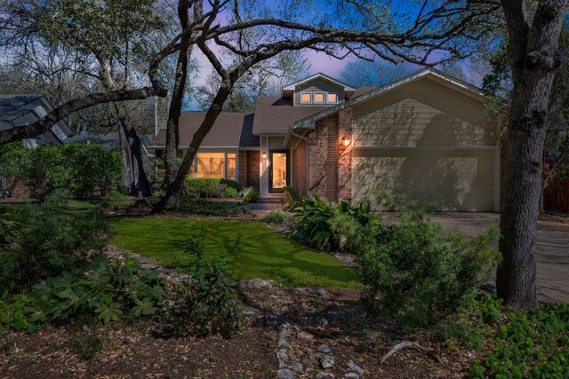 11214 Stormy Ridge Rd, Austin, TX 78739 - view of front of property featuring brick siding, an attached garage, driveway, a front yard, and roof with shingles