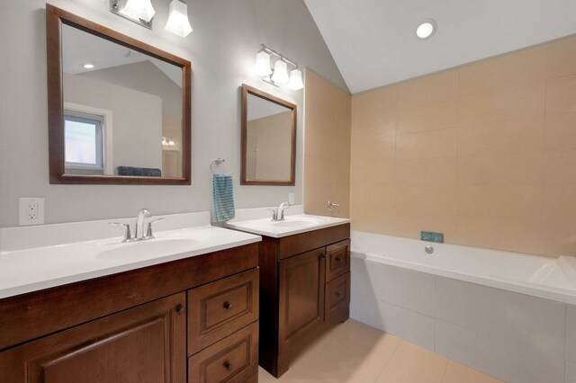 11214 Stormy Ridge Rd, Austin, TX 78739 - full bath featuring two vanities, tiled bath, vaulted ceiling, and tile patterned floors