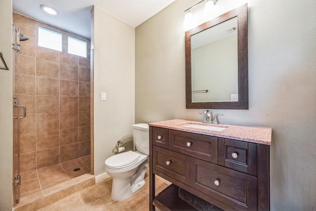 full bath featuring a stall shower, toilet, vanity, and tile patterned flooring