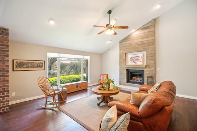 living area with a fireplace, a ceiling fan, wood-type flooring, high vaulted ceiling, and baseboards