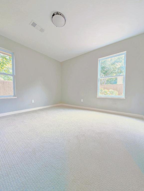 unfurnished room featuring baseboards and light colored carpet