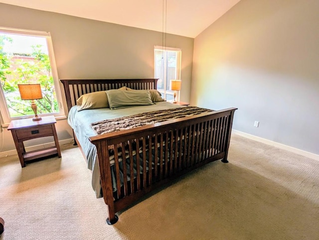 carpeted bedroom with baseboards and lofted ceiling
