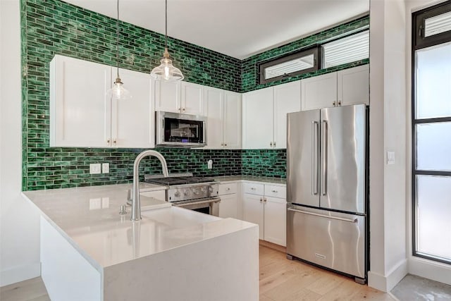 2525 S Lamar Blvd Unit 204, Austin, TX 78704 - kitchen featuring stainless steel appliances, a peninsula, white cabinetry, and light countertops