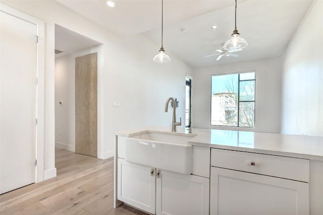 2525 S Lamar Blvd Unit 204, Austin, TX 78704 - kitchen with light wood-style flooring, light countertops, white cabinetry, decorative light fixtures, and recessed lighting