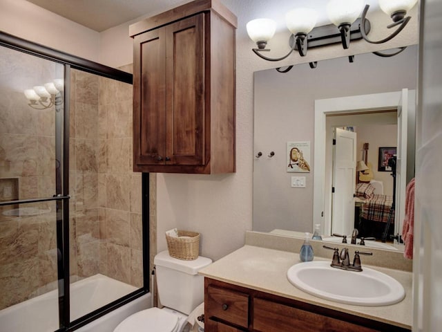 full bath with combined bath / shower with glass door, toilet, an inviting chandelier, and vanity