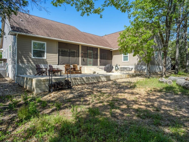 back of property featuring a sunroom, a patio, and a shingled roof