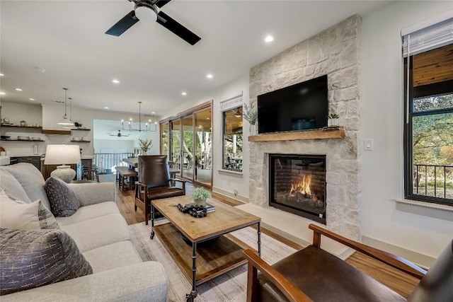 7601 Bar K Ranch Rd, Lago Vista, TX 78645 - living room with a ceiling fan, a fireplace, light wood finished floors, recessed lighting, and a chandelier
