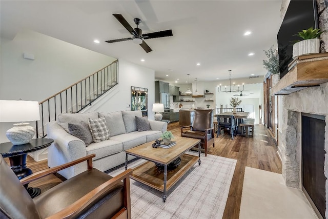 7601 Bar K Ranch Rd, Lago Vista, TX 78645 - living room featuring wood finished floors, stairs, recessed lighting, a ceiling fan, and a fireplace