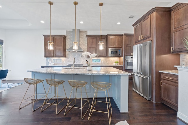 510 Doe Whisper Way, Austin, TX 78738 - kitchen with appliances with stainless steel finishes, wall chimney range hood, a kitchen breakfast bar, decorative backsplash, and recessed lighting