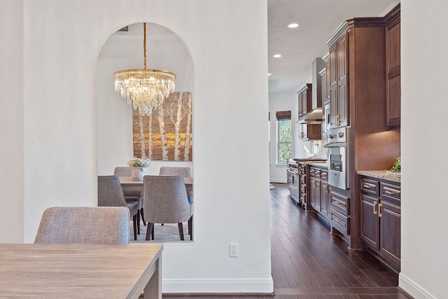 510 Doe Whisper Way, Austin, TX 78738 - dining room featuring a chandelier, arched walkways, dark wood-style floors, and recessed lighting