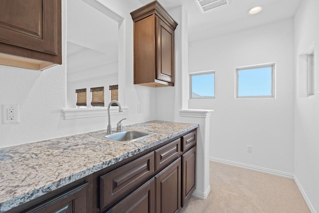 510 Doe Whisper Way, Austin, TX 78738 - kitchen with light colored carpet, light stone counters, dark brown cabinetry, and recessed lighting