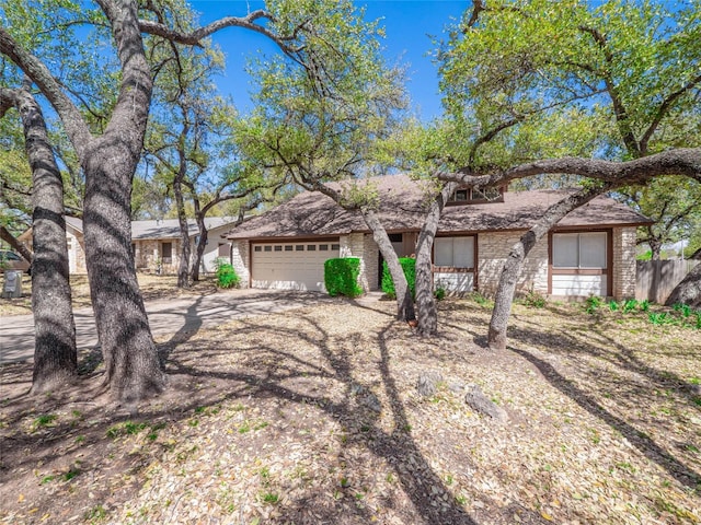 view of front of house featuring driveway, a garage, and stone siding