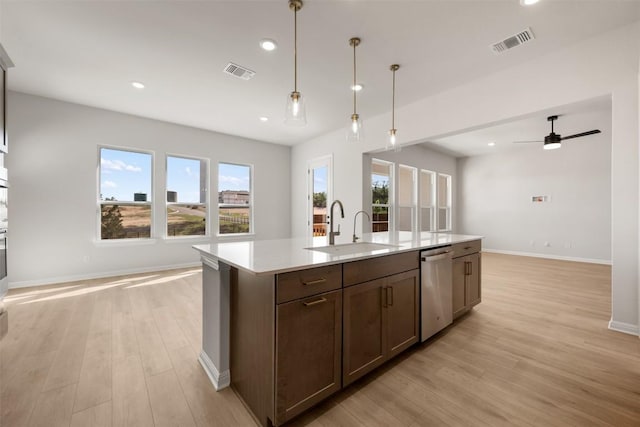 kitchen with open floor plan, light wood-style flooring, visible vents, and a sink