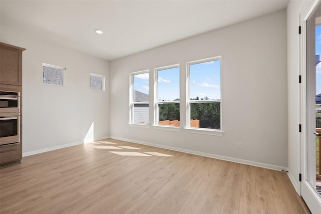 unfurnished living room featuring baseboards, light wood-style floors, and recessed lighting