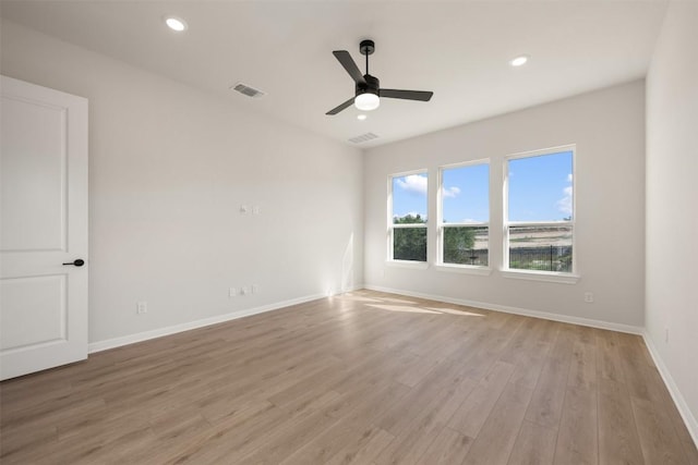 spare room with light wood-style floors, visible vents, baseboards, and ceiling fan