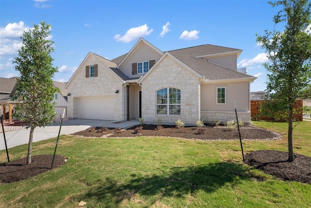 traditional-style home featuring concrete driveway, stucco siding, stone siding, and a front yard