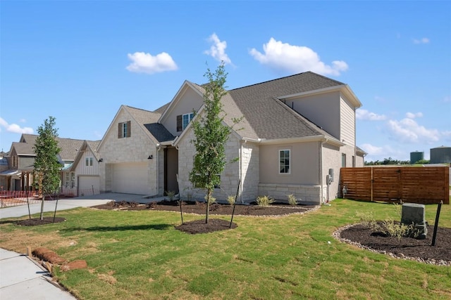 view of front facade with stone siding, a front yard, concrete driveway, and fence