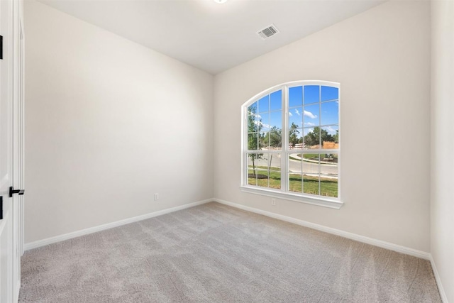 unfurnished room with visible vents, baseboards, and light carpet