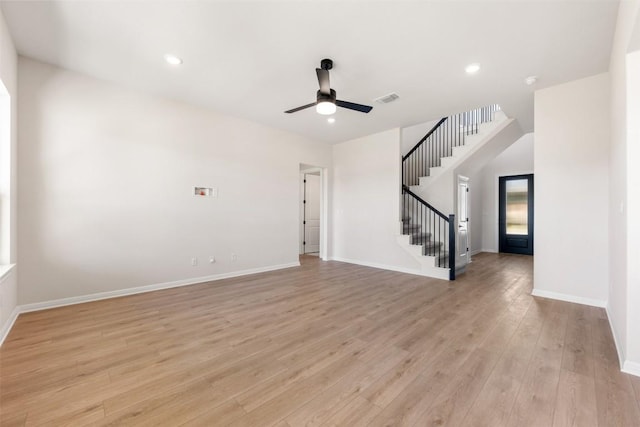 unfurnished living room with stairway, visible vents, light wood-style floors, baseboards, and ceiling fan