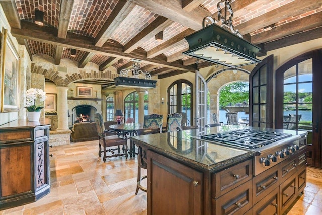 6704 Pixie Cv, Austin, TX 78746 - kitchen with stainless steel gas cooktop, brick ceiling, stone tile floors, arched walkways, and beamed ceiling