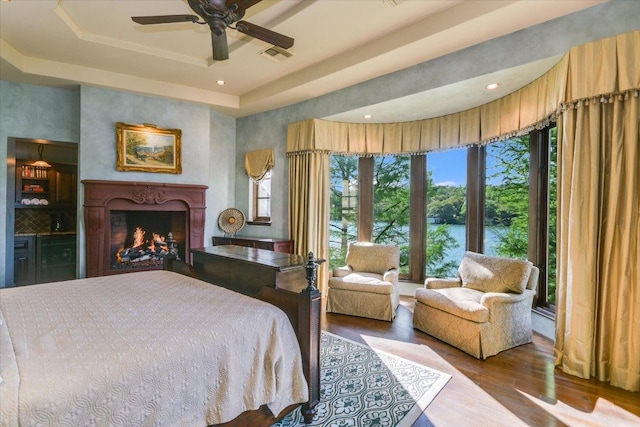 6704 Pixie Cv, Austin, TX 78746 - bedroom with wood finished floors, a raised ceiling, a high end fireplace, a ceiling fan, and recessed lighting
