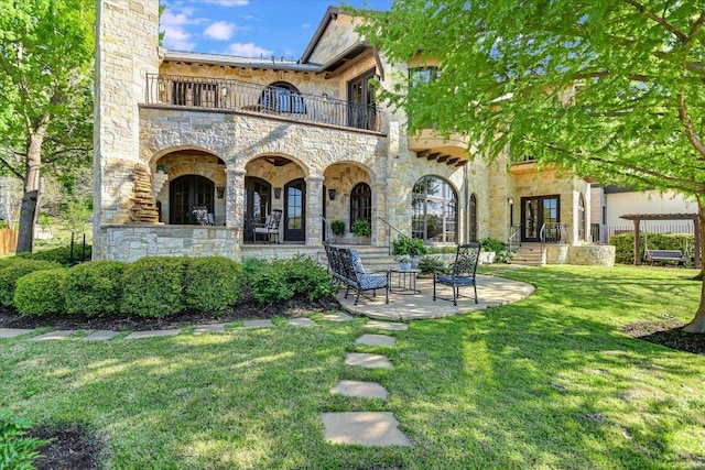 6704 Pixie Cv, Austin, TX 78746 - rear view of house with a balcony, stone siding, and a yard