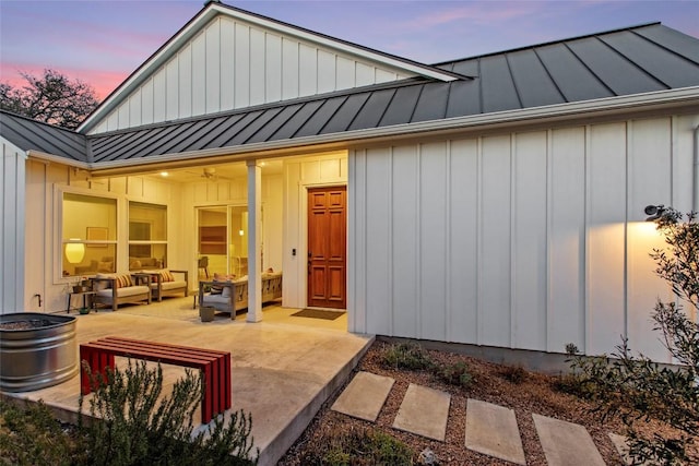 130 Volterra Ln, Dripping Springs, TX 78620 - back of property with a standing seam roof, an outdoor living space, board and batten siding, metal roof, and a patio