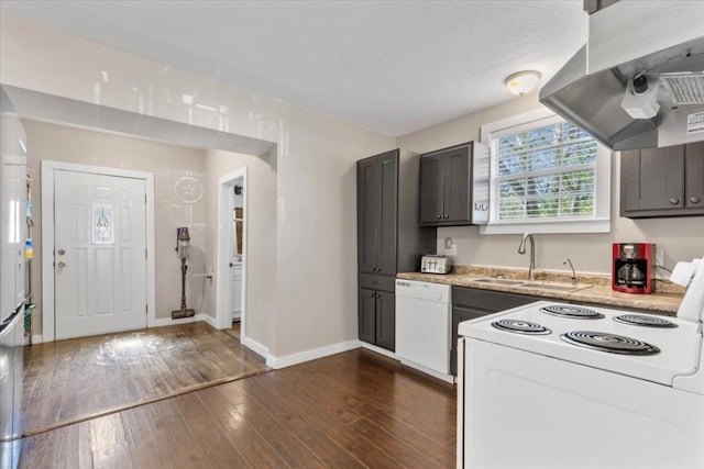 708 Baumgarten St, Schulenburg, TX 78956 - kitchen with white appliances, wall chimney range hood, light countertops, and dark wood finished floors