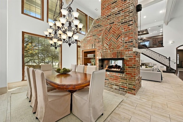 114 Flying Scot St, Lakeway, TX 78734 - dining space with a high ceiling, a brick fireplace, a chandelier, recessed lighting, and stairway