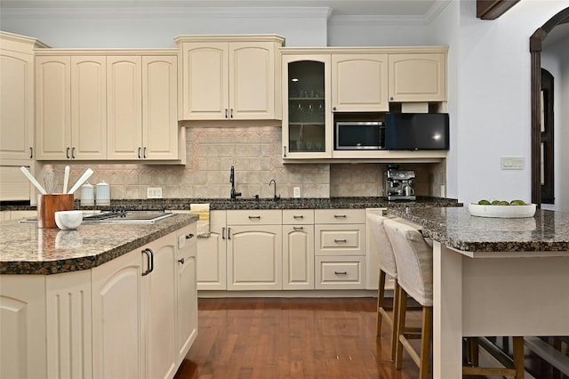 114 Flying Scot St, Lakeway, TX 78734 - kitchen with cream cabinetry, crown molding, a center island, dark wood-style floors, and decorative backsplash