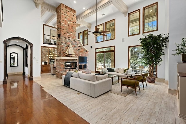 114 Flying Scot St, Lakeway, TX 78734 - living room featuring ceiling fan, arched walkways, a towering ceiling, beam ceiling, and baseboards