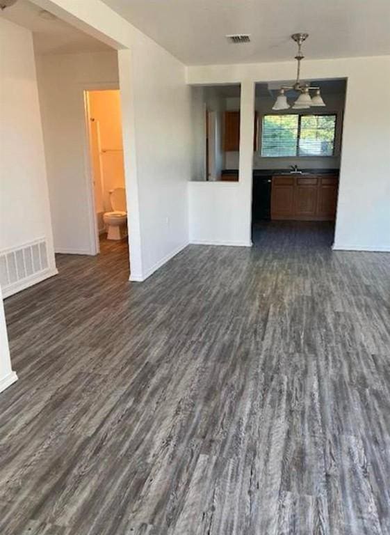 13217 Perconte Dr, Del Valle, TX 78617 - unfurnished living room featuring dark wood-style flooring and baseboards