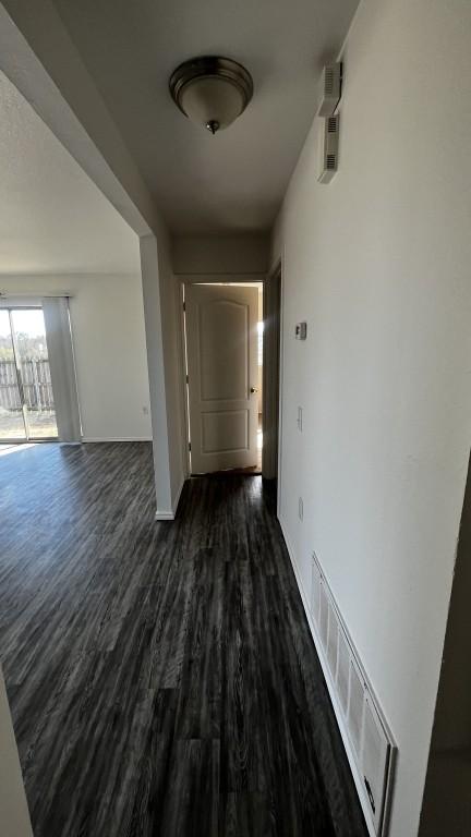 13217 Perconte Dr, Del Valle, TX 78617 - hall featuring dark wood-type flooring and baseboards