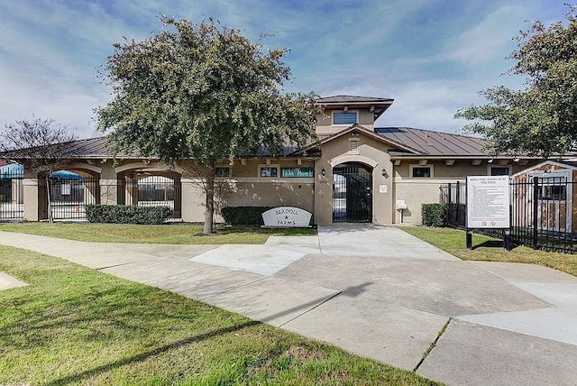 13217 Perconte Dr, Del Valle, TX 78617 - view of front of house featuring stucco siding, a standing seam roof, and a fenced front yard