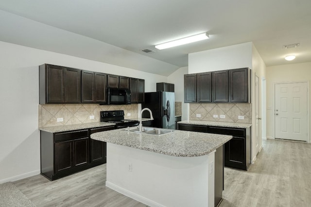 11648 Cambrian Rd, Manor, TX 78653 - kitchen featuring black appliances, a sink, light wood-type flooring, vaulted ceiling, and dark brown cabinets