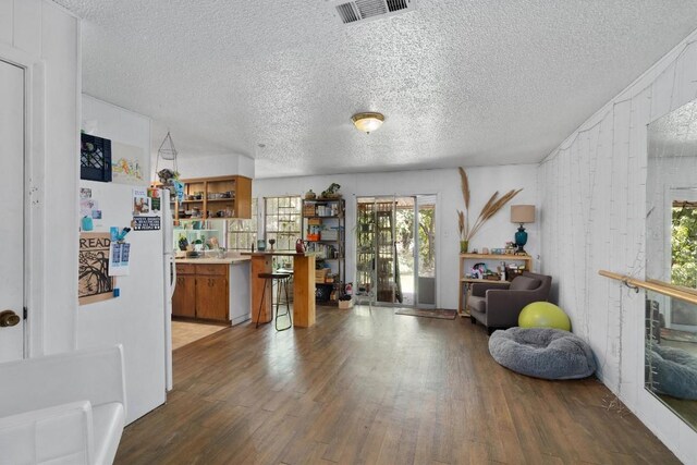 1905 Chestnut Ave, Austin, TX 78722 - interior space featuring wood finished floors, a textured ceiling, and freestanding refrigerator