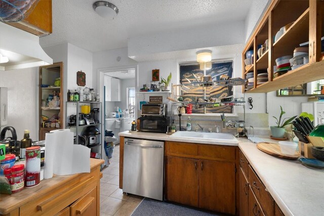 1905 Chestnut Ave, Austin, TX 78722 - kitchen featuring stainless steel dishwasher, light countertops, open shelves, a textured ceiling, and light tile patterned floors