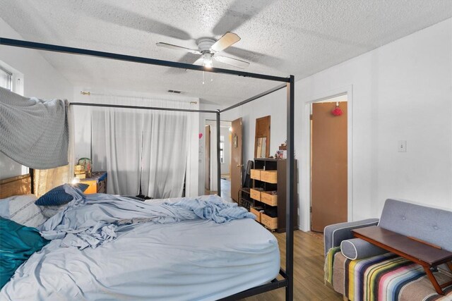 1905 Chestnut Ave, Austin, TX 78722 - bedroom featuring a textured ceiling, wood finished floors, and ceiling fan