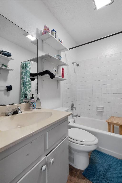 1905 Chestnut Ave, Austin, TX 78722 - full bath featuring vanity, shower / bathtub combination with curtain, wood finished floors, and a textured ceiling