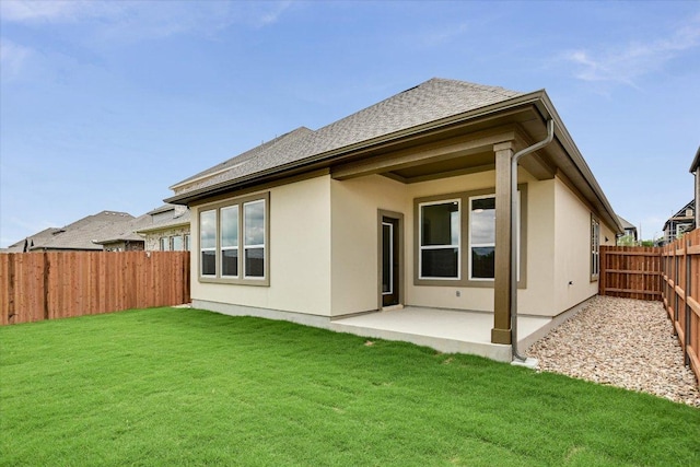 1409 S Brook Dr, Leander, TX 78641 - back of property featuring a fenced backyard, a patio area, stucco siding, and a shingled roof
