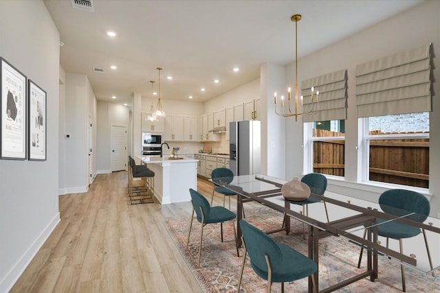1409 S Brook Dr, Leander, TX 78641 - dining area with a chandelier, light wood finished floors, and recessed lighting