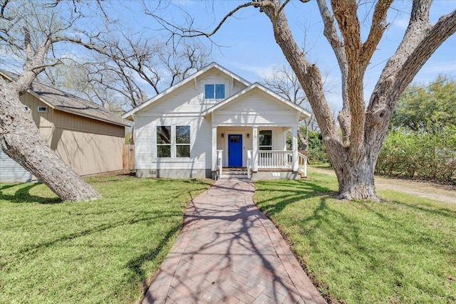 bungalow with covered porch and a front yard