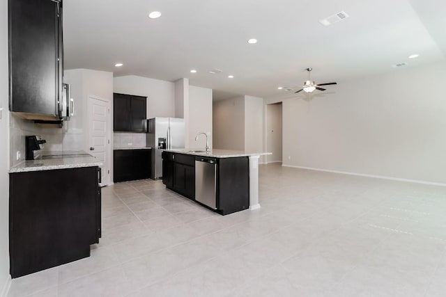 20411 Rockpark Ln, Lago Vista, TX 78645 - kitchen with appliances with stainless steel finishes, a ceiling fan, backsplash, dark cabinetry, and open floor plan