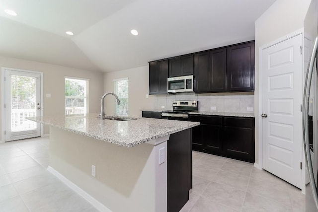 20411 Rockpark Ln, Lago Vista, TX 78645 - kitchen with appliances with stainless steel finishes, light tile patterned flooring, lofted ceiling, light stone countertops, and decorative backsplash