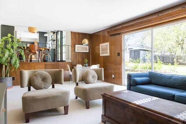 carpeted living room featuring wooden walls