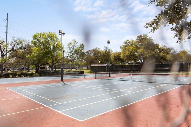 view of tennis court featuring fence and community basketball court